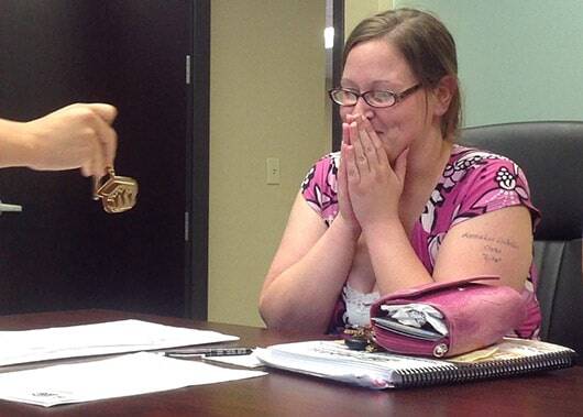 An emotional homeowner receiving the keys to her first home.