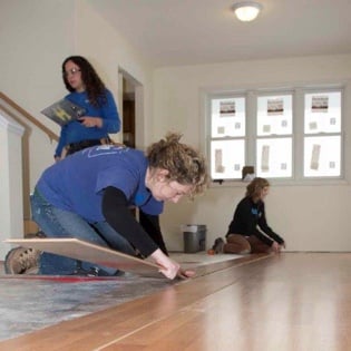 Director of Donor and Volunteer Development installing flooring