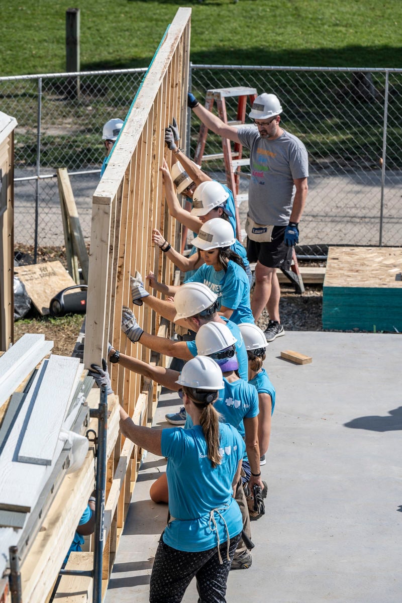 volunteers lifting a wall
