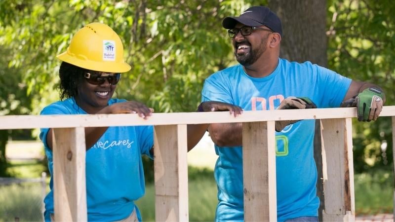 2 volunteers laughing.