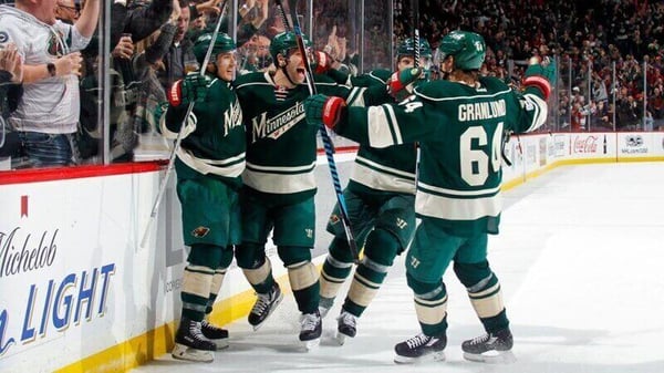 Members of the Minnesota Wild celebrating on the ice.