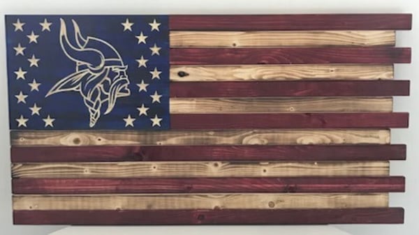 A painted wooden flag with the Vikings logo surrounded by stars.