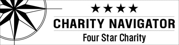 A white banner with black text and a black Charity Navigator logo on the left. To the right is four stars above the text "CHARITY NAVIGATOR Four Star Charity".