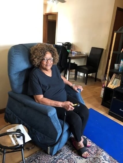 Katie in a blue chair in her home.