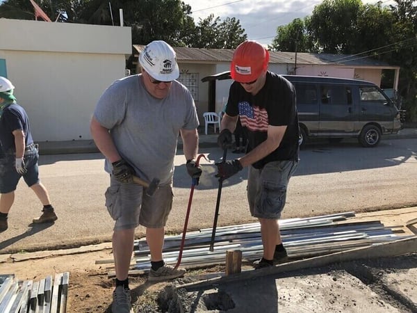 Chad and Joe working on the foundation of a house.