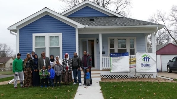 A family standing in front of their new Habitat home.