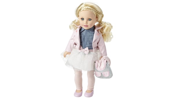 A blond doll with pigtails, wearing a denim shirt, a white skirt with a pink bow, a pink jacket with leggings and pink shoes, as well as a gray and pink backpack.