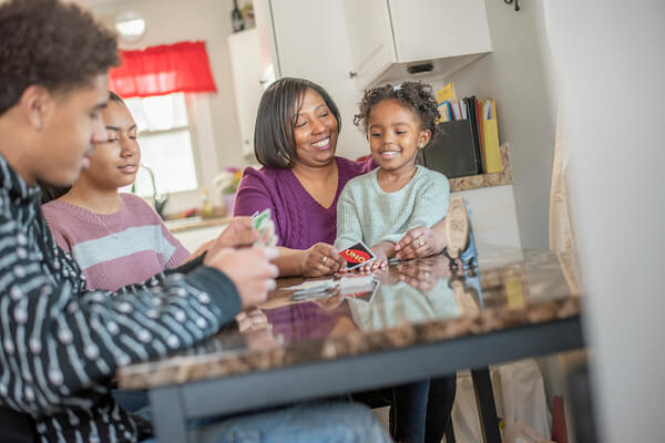 LaShonda and her family sitting at the kitchen table playing Uno.