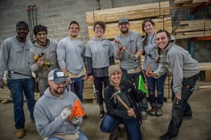 Several AmeriCorps members posing with various tools.