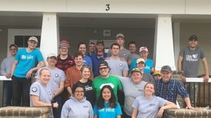 An AmeriCorps cohort on their service trip, posing on the porch of a house.