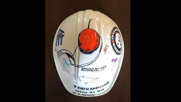 A white hard hat decorated with markers.
