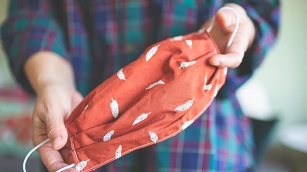 A red mask with white pepper designs being held and displayed.