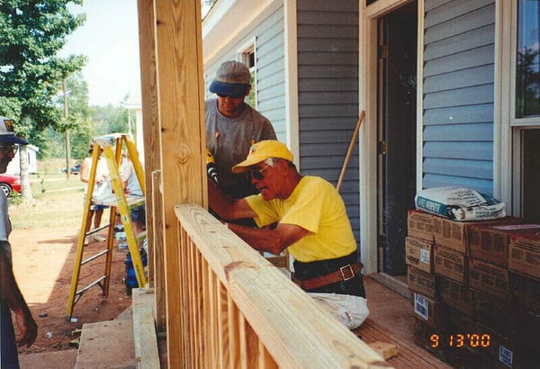 Kenny working on a porch with other volunteers, photo dated 9/13/2000.