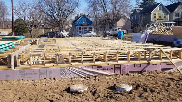 A Habitat employee and AmeriCorps member working on framing a house.