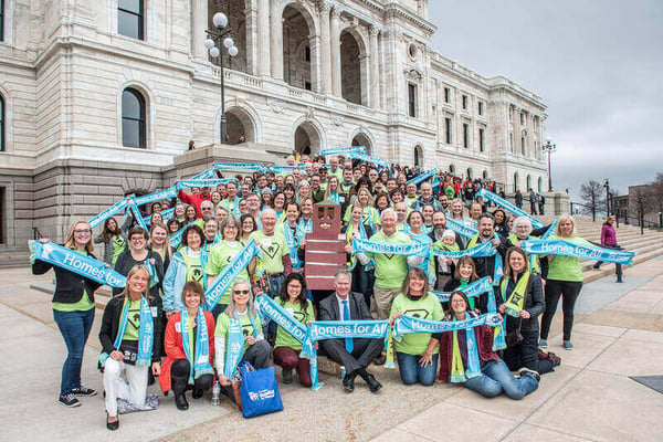 A large group of advocates at Habitat on the Hill 2019, holding "Homes for All" banners.