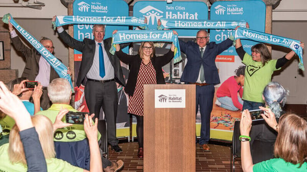 Leaders and housing advocates holding "Homes for All" banners at Habitat on the Hill 2019.