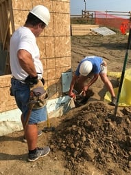 Two Pax Christi volunteers working outside a house