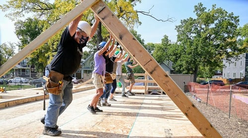 Volunteers raising a wall.