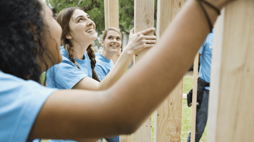 Group of teens volunteering on a home build with habitat.