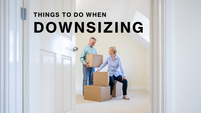 A couple moving boxes in a white room.