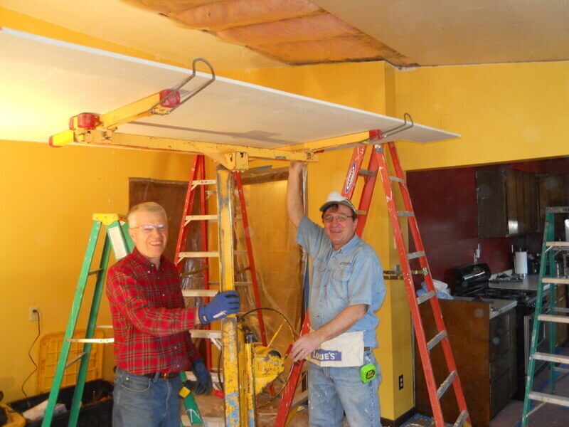 A photo of Jerry & Phil volunteering inside a home.
