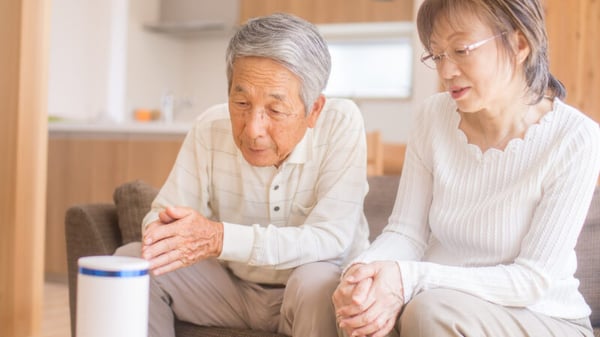 A husband and wife using a smart speaker.