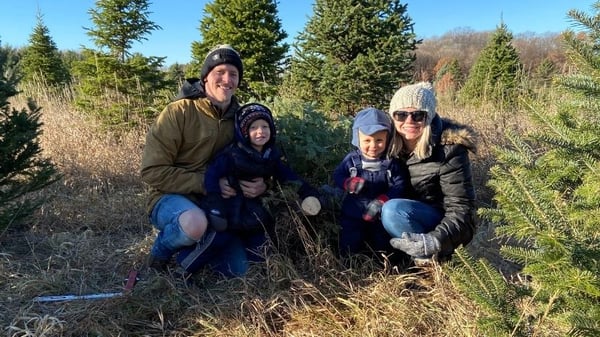 Bethany Rogness with her husband and two kids outdoors.