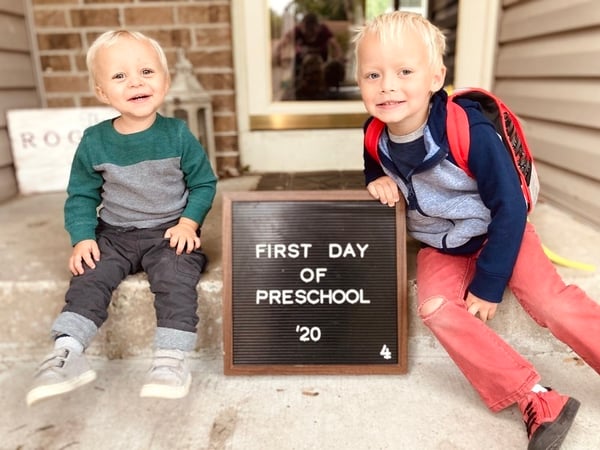 The Rogness kids on their front steps with a sign saying "First day of preschool '20."