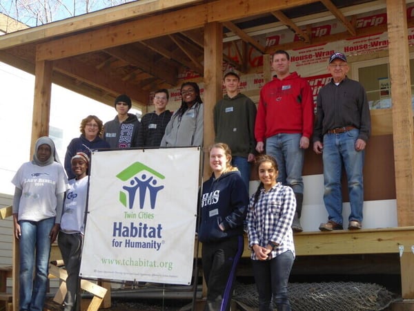 High school students in front of an in-progress home build.