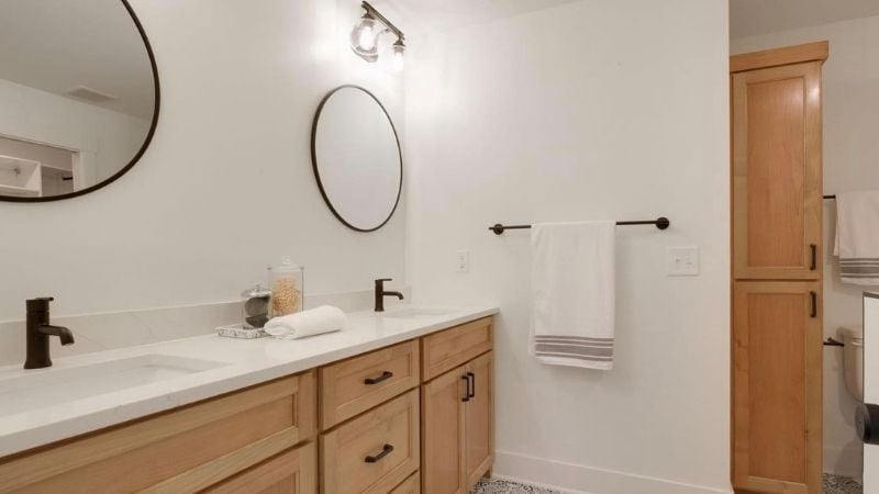 Updated bathroom with wood cabinets and bronze finishes.