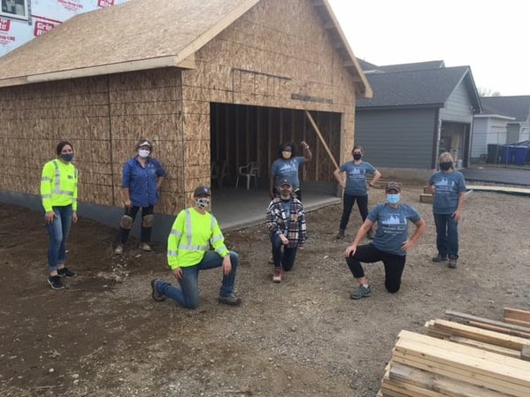 A group of volunteers celebrating progress on a garage.