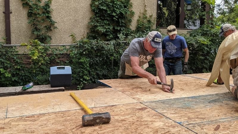 Chris Coleman and other GV Gone Local volunteers work on subfloor installation at 3238 Vincent Ave N.