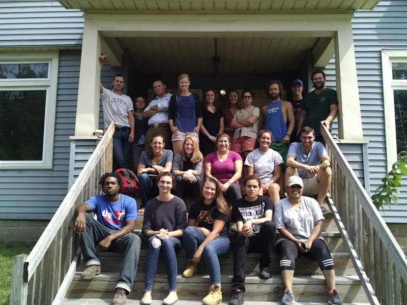 2016 AmeriCorps members on the front steps of the fourplex, posed and smiling