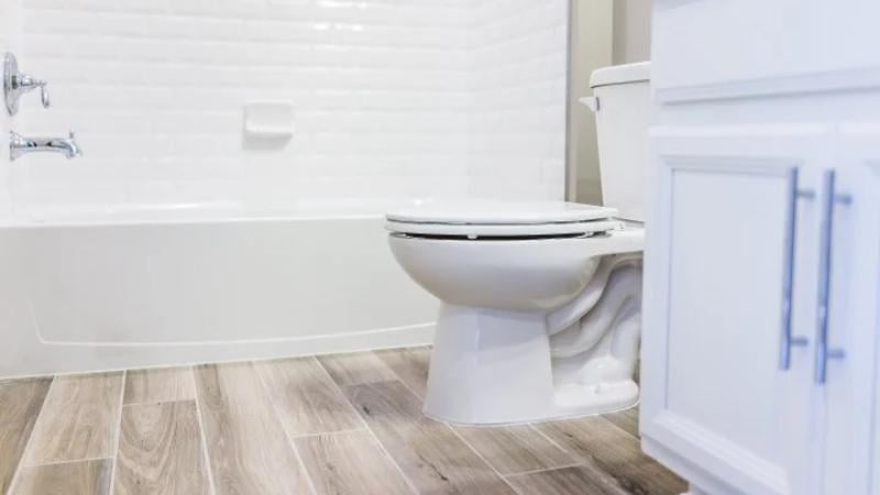 A bathroom with new vinyl wood-look flooring.