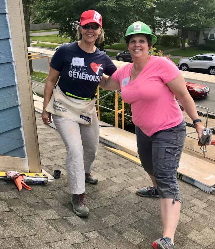 Nikki Sorum on a roof with her sister at a build day.