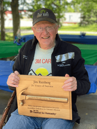 Jim with his Golden Hammer on a wooden placard.