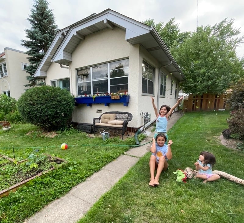 Matias and Camila's two kids being silly in the front yard with a friend.