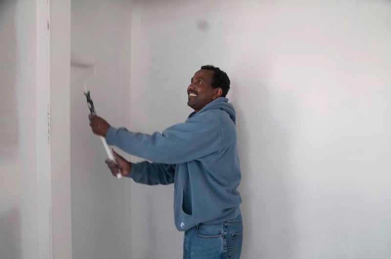 Hassan painting at all staff build day