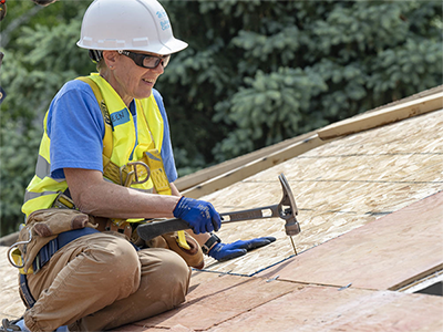 Kathleen hammering on a roof.