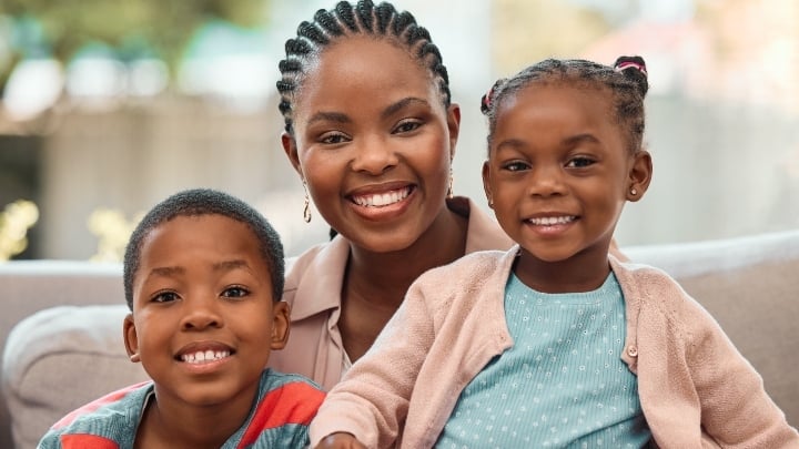 A mom and her two kids smiling.