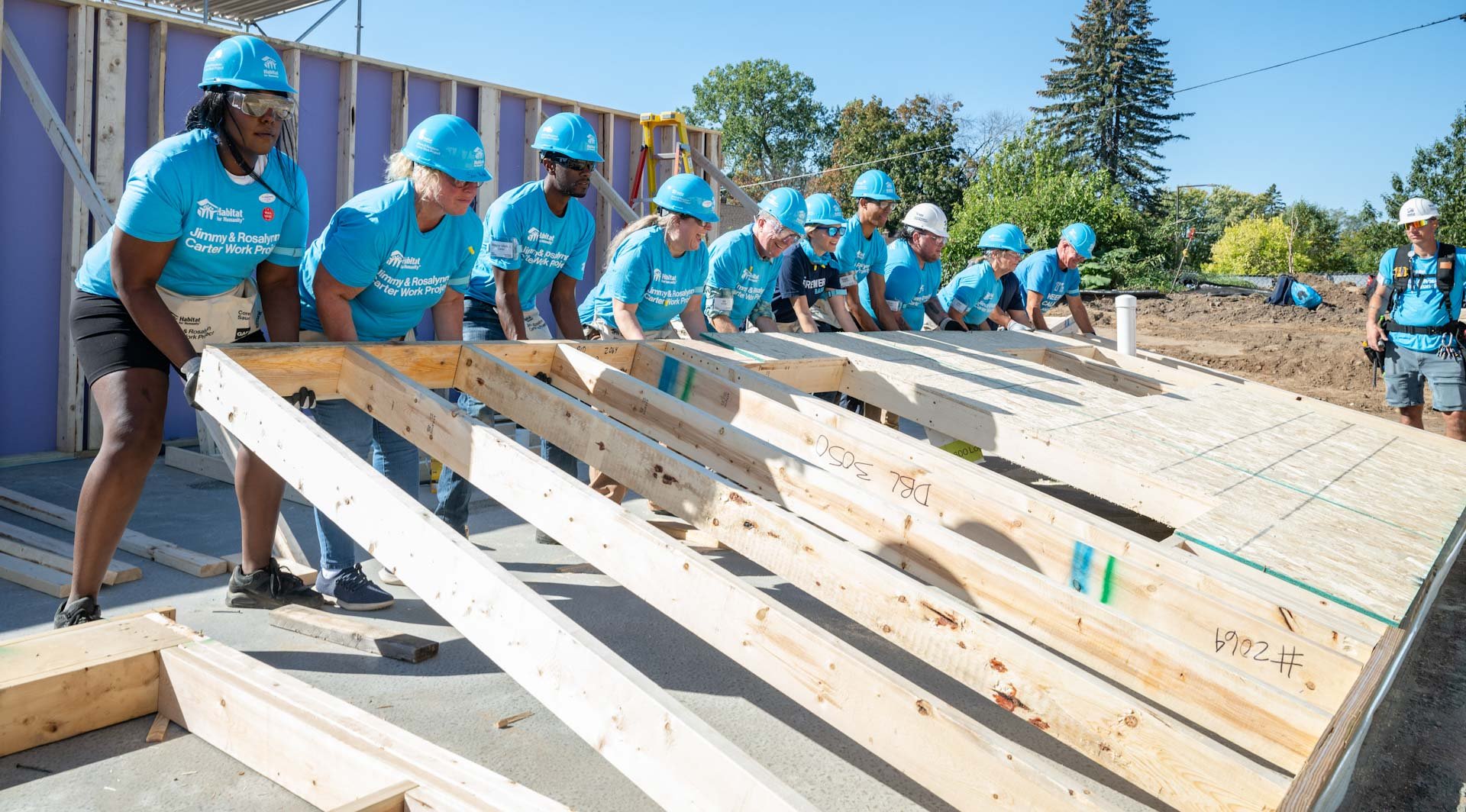 Volunteers raising a wall frame.