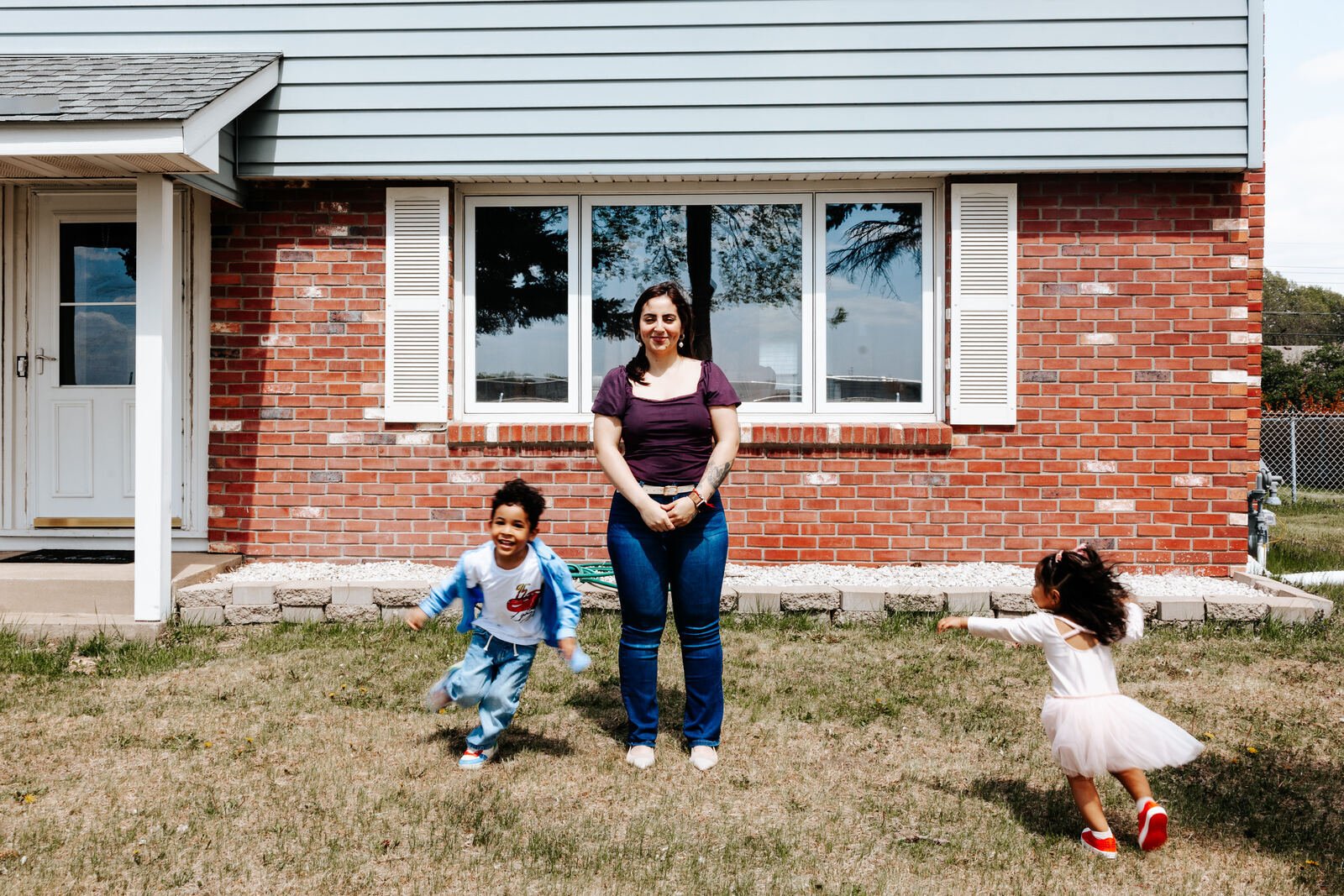 Linda and her kids running in the yard.