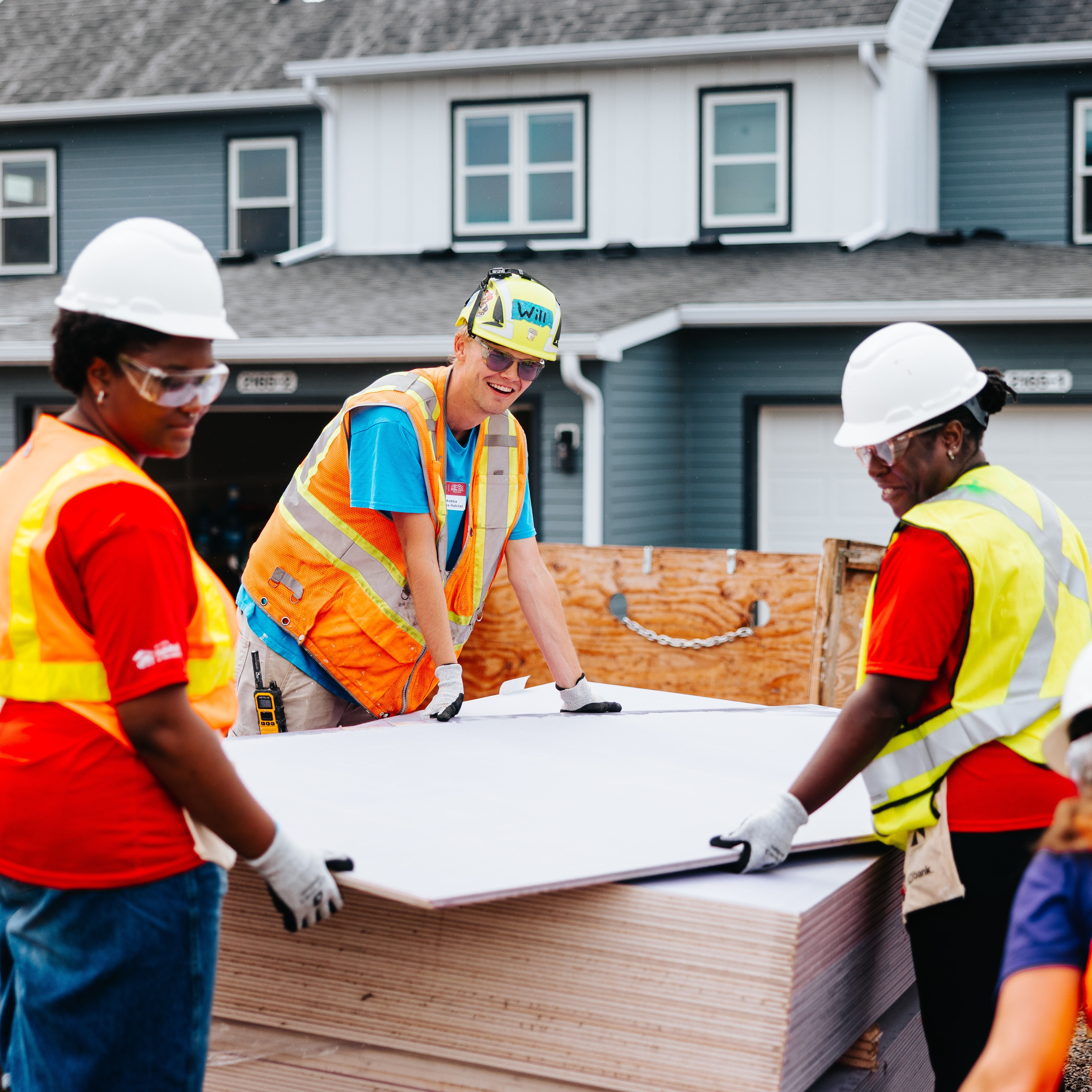 Volunteers carrying wooden board.