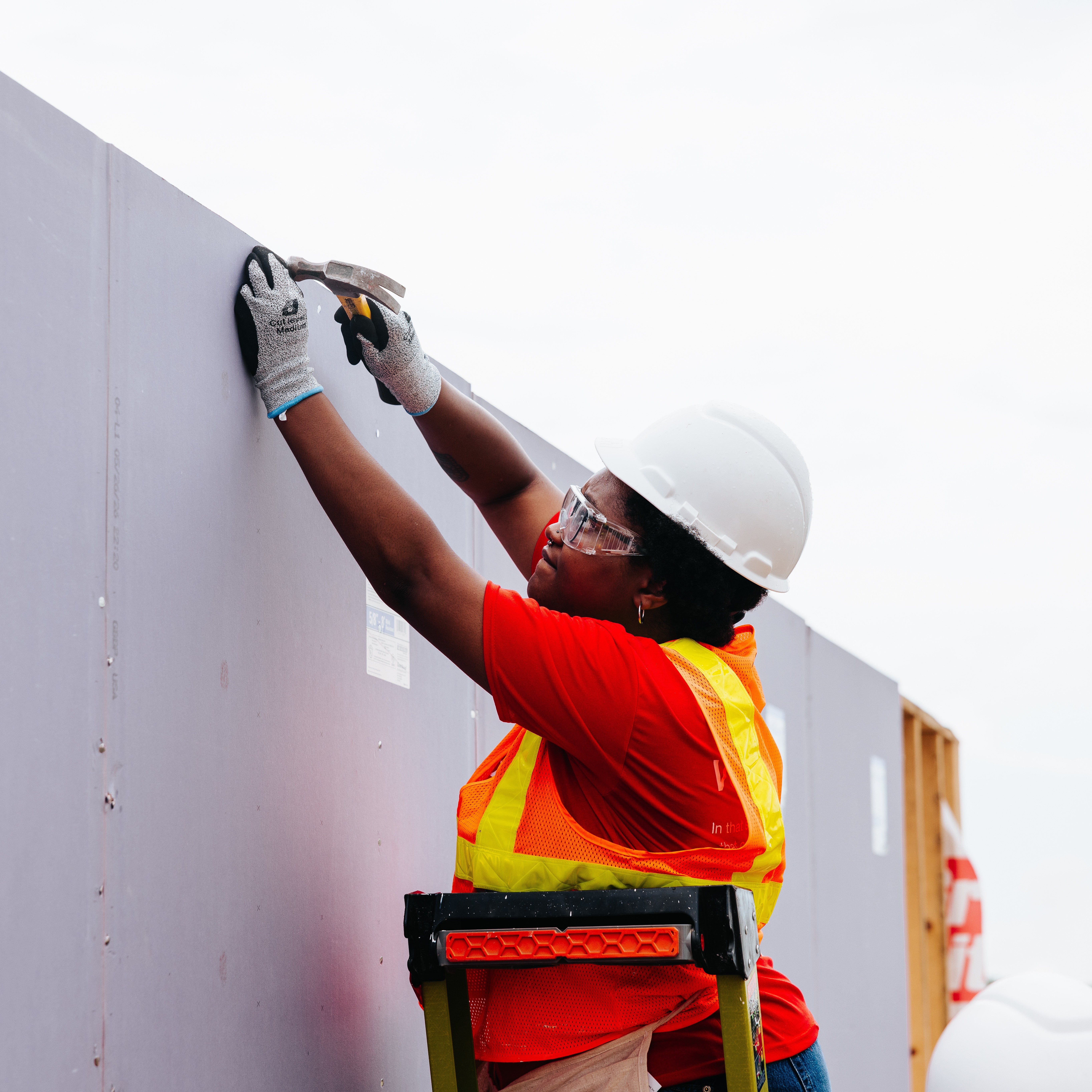 Volunteer hammering the wall.