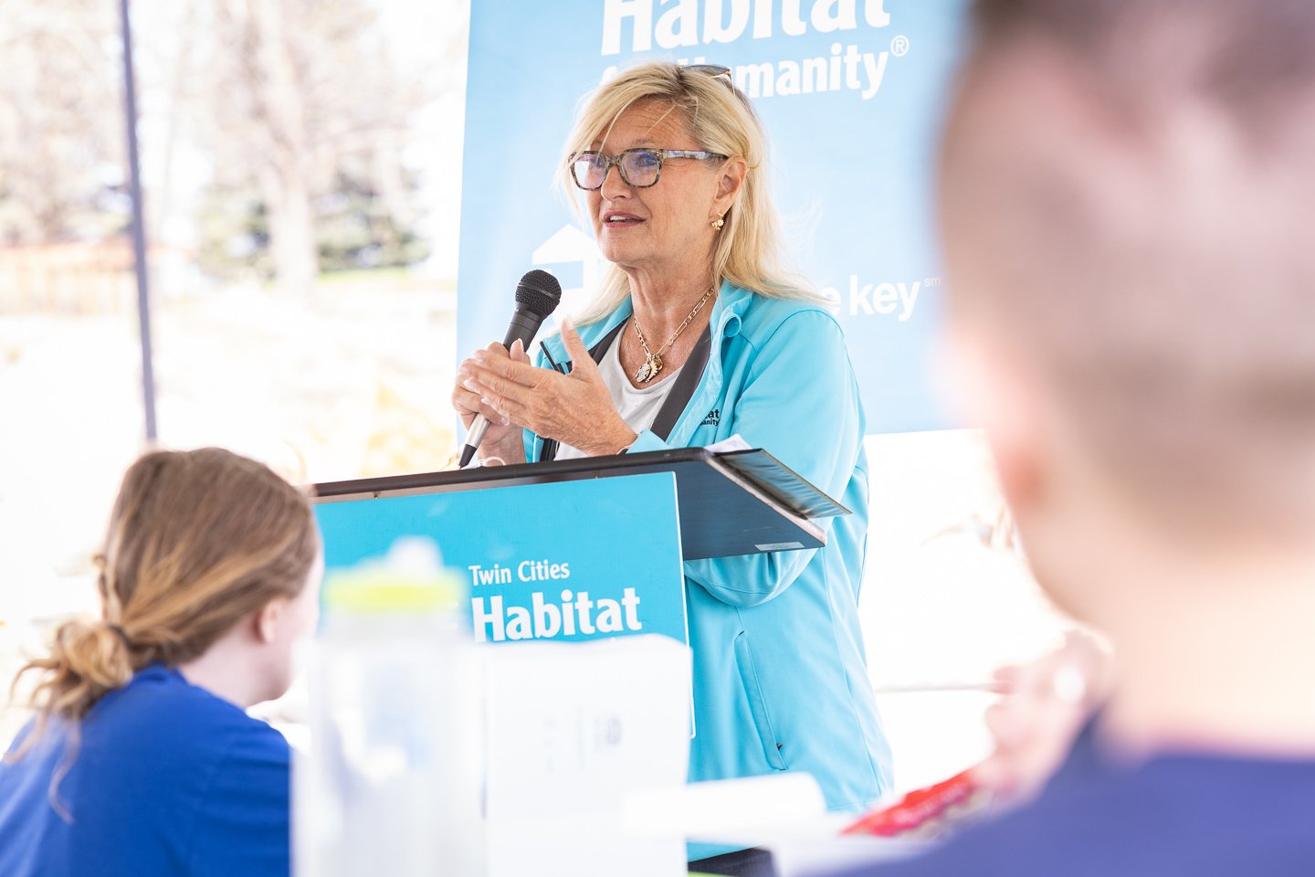 Ann Hart speaking at a podium.