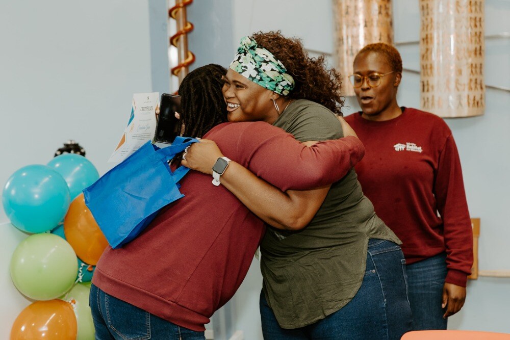 Hug between Habitat employee and program participant.