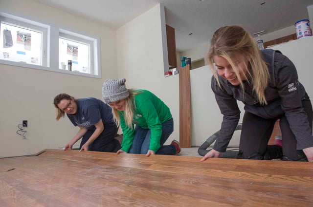 Allie laying flooring at a Habitat build site