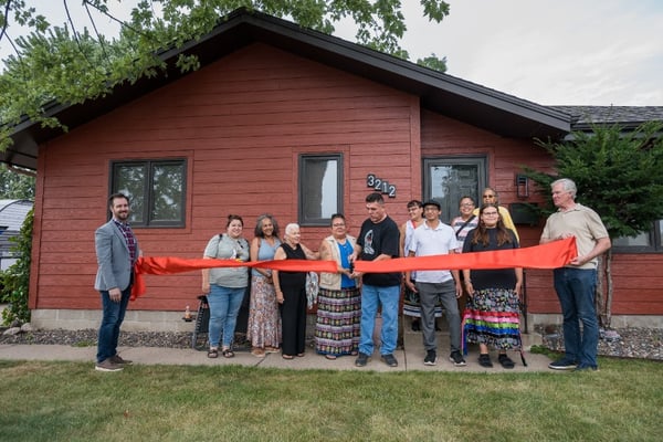 Angeline and Allen cutting a large red ribbon.