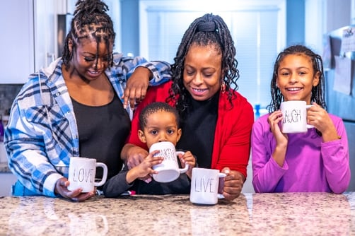 Arlisa and her three kids holding mugs and laughing.