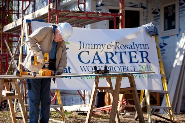 President Carter using a drill on the build site.
